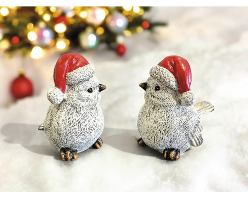 Deux oiseaux décoratifs avec des bonnets de Noël comme décorations de Noël