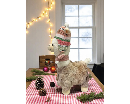 Dekorative Lama-Figur mit Mütze und Schal auf einem Tisch