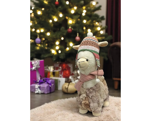 Dekoratives Lama Plüschtier mit Mütze und Schal vor Weihnachtsbaum und Geschenken