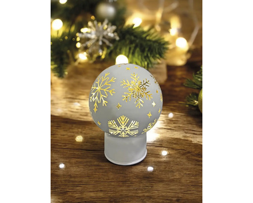 Dekoratives Weihnachtsobjekt mit Schneeflockenmuster auf einem Holztisch