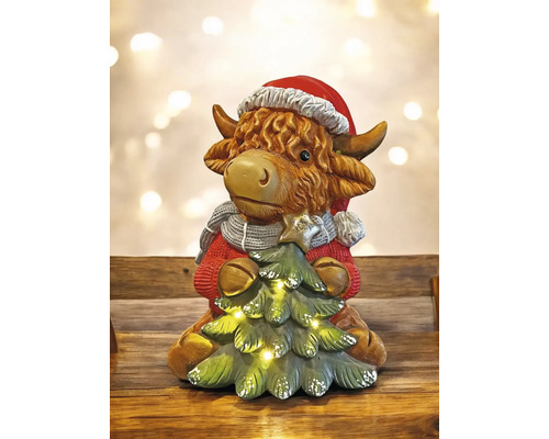 Figurine décorative de vache avec bonnet de Noël et sapin de Noël avec des lumières.