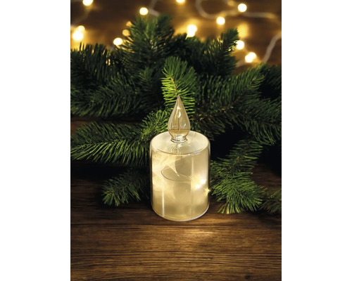 Dekorative LED-Kerze mit Tannenzweigen auf Holztisch