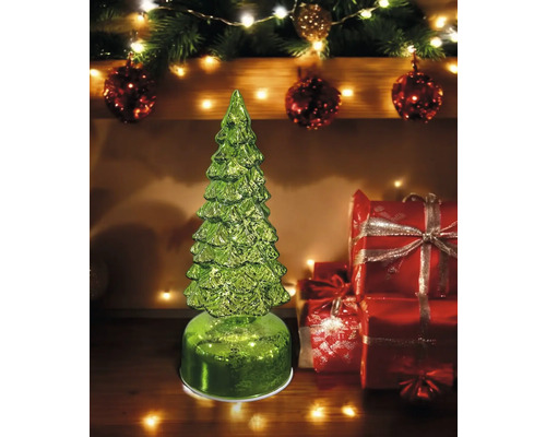 Dekorativer, grüner Weihnachtsbaum aus Glas mit Geschenkboxen im Hintergrund als festliche Dekoration.