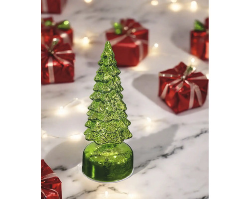 Dekorative grüne Tannenbaumfigur neben roten Geschenken