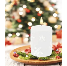 Bougie décorative avec motif de flocon de neige sur une assiette en bois avec des branches de sapin