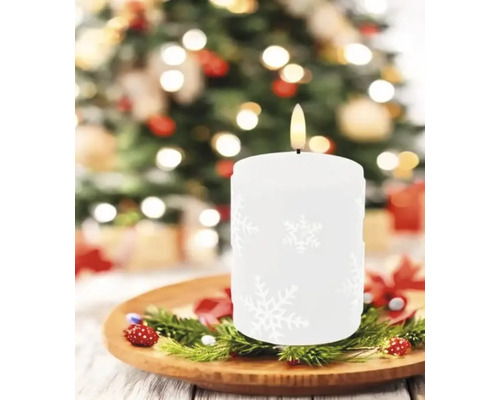 Bougie décorative avec motif de flocon de neige sur une assiette en bois avec des branches de sapin
