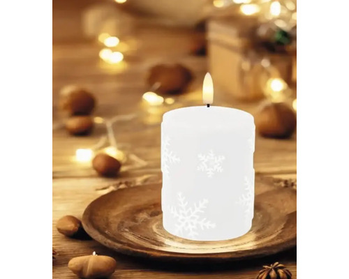 Bougie décorative blanche avec motif de flocon de neige sur une assiette