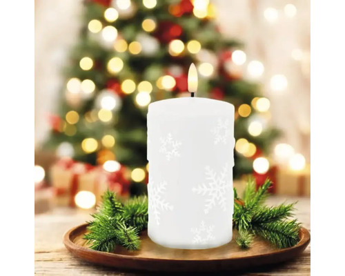 Bougie LED décorative avec motif de flocons de neige sur une assiette en bois, un arbre de Noël en arrière-plan