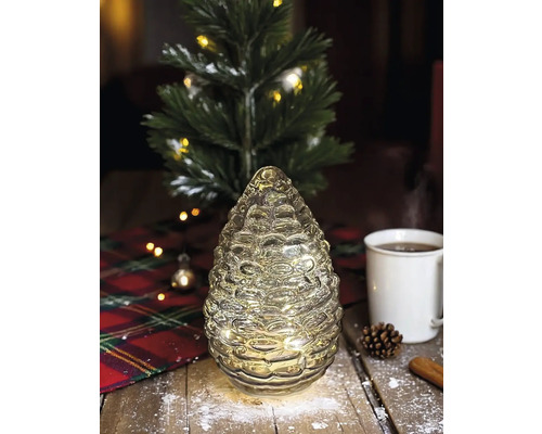 Dekorative, beleuchtete Tannenzapfenfigur auf einem Tisch mit Weihnachtsdekoration