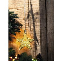 Dekoration mit Sternform und Lichterkette vor Holzwand