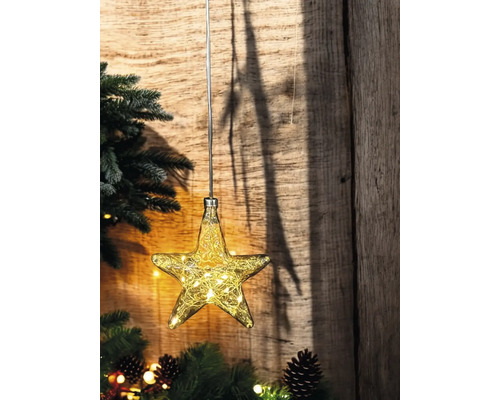 Décoration en forme d''étoile avec guirlande lumineuse devant un mur en bois