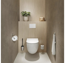 Salle de bains avec WC suspendu, porte-papier toilette, brosse WC et serviette