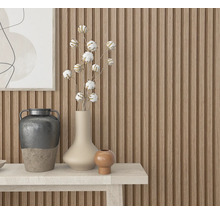 Dekoratives Arrangement mit Vasen und Baumwollzweigen auf einem Tisch vor einer Holzpaneelwand