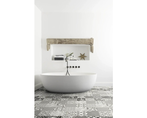 Salle de bains lumineuse avec baignoire îlot et carrelage à motifs