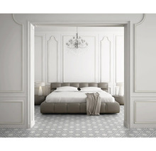 Chambre avec lit, tables de chevet, lampe, lustre et sol à motifs