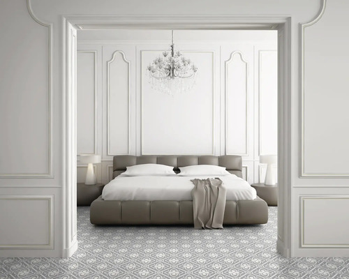 Chambre avec lit, tables de chevet, lampe, lustre et sol à motifs