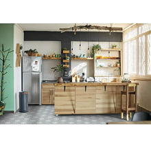 Cuisine claire avec îlot de cuisson, étagères et réfrigérateur en acier inoxydable.