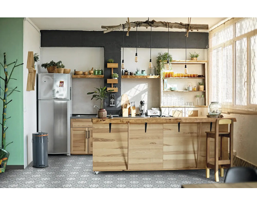 Cuisine claire avec îlot de cuisson, étagères et réfrigérateur en acier inoxydable.