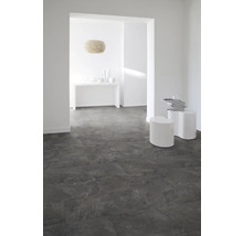 Pièce lumineuse avec sol carrelé foncé, murs blancs et décor minimaliste.