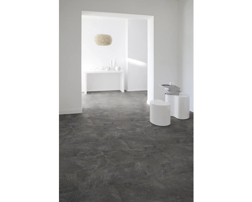 Pièce lumineuse avec sol carrelé foncé, murs blancs et décor minimaliste.