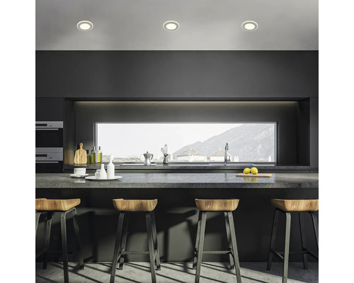 Moderne Küche mit Bartisch, Barhockern und Einbauspots für eine helle Atmosphäre.