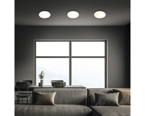 Wohnraum mit Sofa, Tisch und drei Deckenleuchten