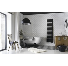 Salle de bain avec baignoire, radiateur, meuble-lavabo et chaise