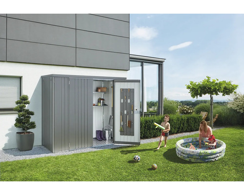 Scène de jardin avec une armoire à outils en métal adossée à un bâtiment et dans laquelle des outils sont rangés. Des enfants jouent dans une piscine gonflable.