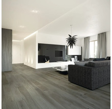 Salon lumineux avec canapé, télévision et plancher en bois.