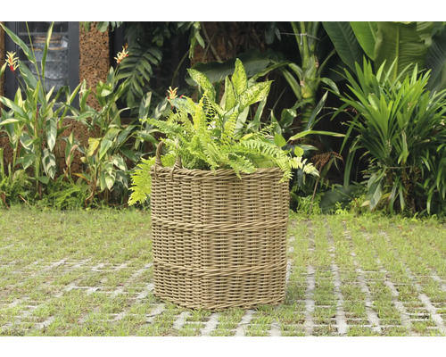 Cache-pot tressé avec des plantes dans le jardin.