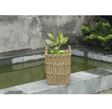 Panier à plantes décoratif en rotin avec plantes sur une terrasse en pierre