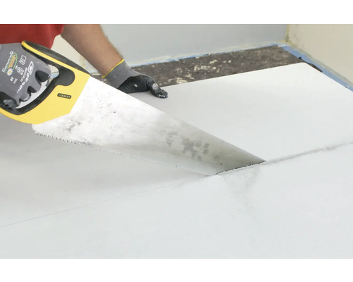 Découpe d''une plaque de construction à l''aide d''une scie à main