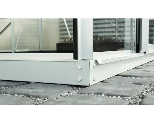 Gros plan d''une serre avec cadre de fondation sur des pavés