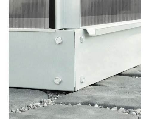 Vue détaillée des fondations d''une serre avec des vis sur des pavés