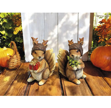 Zwei Eichhörnchenfiguren mit Nuss-Mützen, die Geschenk und Tannenbaum halten
