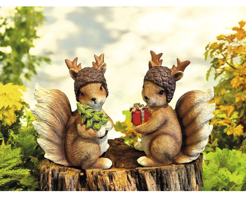 Zwei Eichhörnchenfiguren mit Mützen und Geweih auf Baumstumpf, eines mit Weihnachtsbaum, eines mit Geschenk
