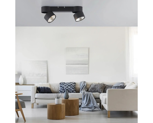 Wohnzimmer mit Sofa, Couchtisch und Deckenleuchte mit zwei Strahlern