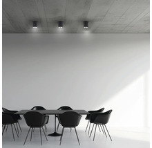 Esszimmer mit schwarzem Tisch, schwarzen Stühlen und Deckenleuchten