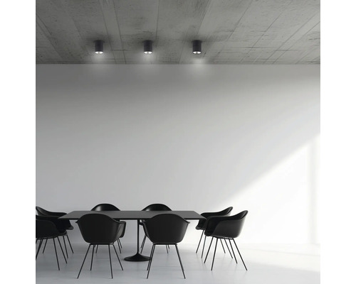 Esszimmer mit schwarzem Tisch, schwarzen Stühlen und Deckenleuchten