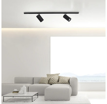 Zwei schwarze Deckenstrahler an einer Schiene in einem hellen Wohnzimmer.