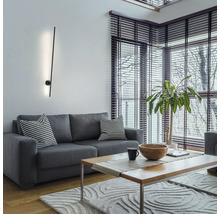 Wohnzimmer mit grauem Sofa, Holztisch und moderner Wandleuchte