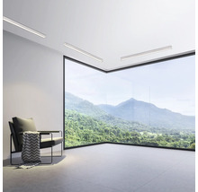 Salon moderne avec fauteuil, plafonniers et baie vitrée avec vue sur la montagne