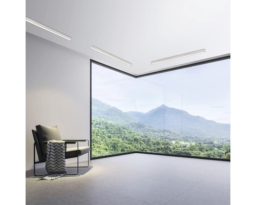 Salon moderne avec fauteuil, plafonniers et baie vitrée avec vue sur la montagne