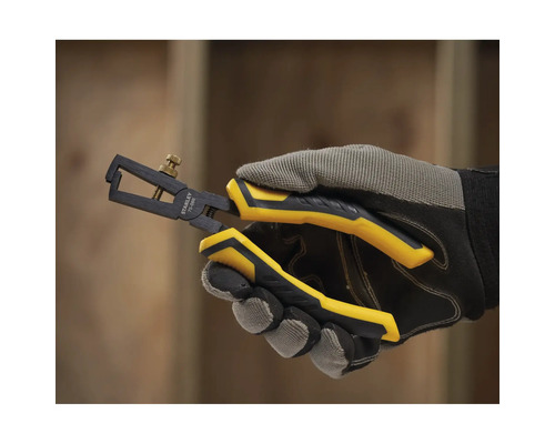 Une main gantée tenant une pince à dénuder Stanley.
