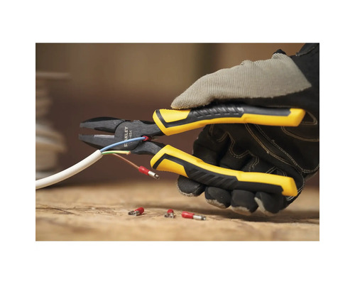 Eine Person mit Handschuhen schneidet mit einer Kombizange ein Kabel.