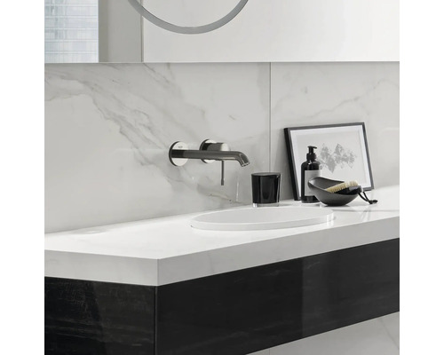 Salle de bains moderne avec lavabo, robinet, distributeur de savon et éléments décoratifs.