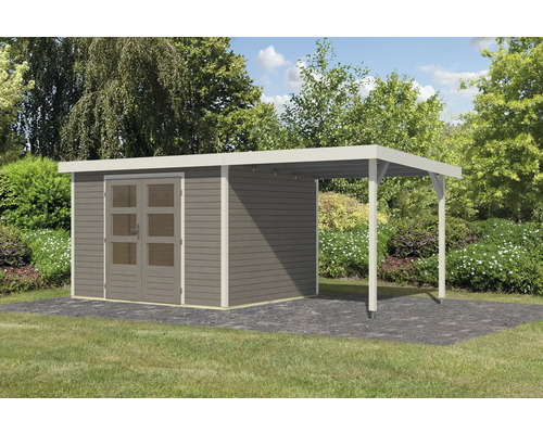 Abri de jardin avec annexe sur une surface pavée devant des arbres