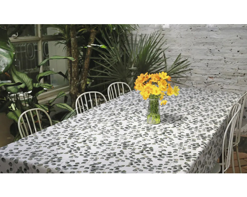 Szene mit Esstisch, Stühlen, Tischdecke mit Blattmuster und Blumenarrangement