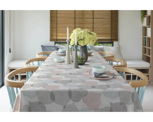 Esstisch mit Blattmuster-Tischdecke, Geschirr und Dekoration