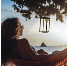 Dekorative Hängeleuchte aus Metall über einer Frau in einer Hängematte am Strand